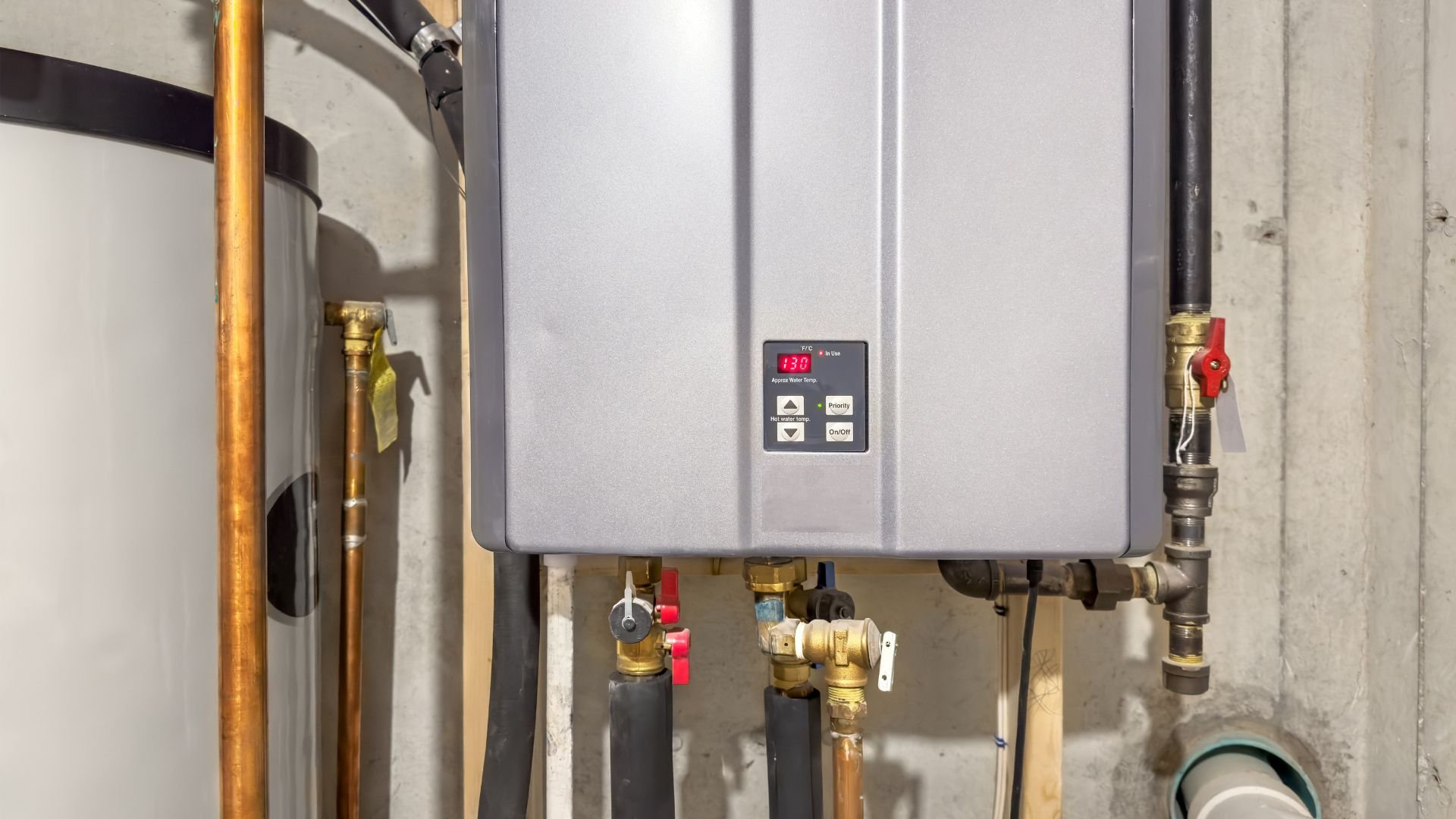 Tankless water heater with copper pipes and valves in utility room